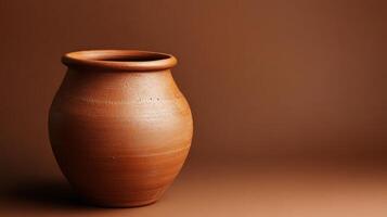 A brown clay vase sitting on a table photo