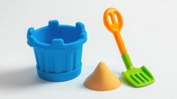 A plastic bucket, shovel and sand are on a white background photo