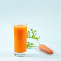 Glass of fresh carrot juice with a carrot photo