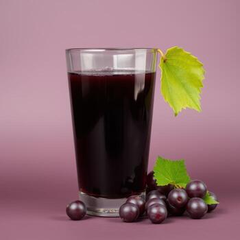 Glass of Grape Juice with Fresh Grapes and Leaves photo