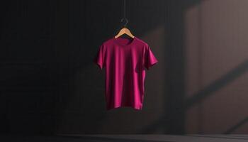 Crimson T-Shirt Hanging on Wooden Hanger Against Dark Background photo