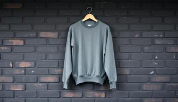 Grey Sweatshirt Hanging on Wooden Hanger Against a Brick Wall photo