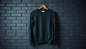 Dark Green Sweatshirt Hanging on Hanger Against Brick Wall photo