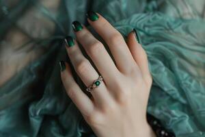 Close-up of a hand with green nail polish and a ring. photo