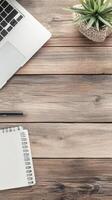 Laptop, Notebook, and Plant on Wooden Desk. photo
