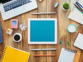 Flat Lay Of A Workspace With A Tablet, Laptop, Notebook, And Other Office Supplies. photo