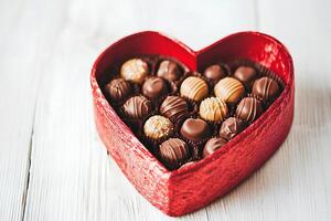 Box of chocolates in the shape of a heart on a white wooden background photo