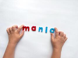 Child spelling with colorful letters manic on white background photo