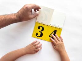 Intergenerational learning with a calendar featuring bold numbers photo