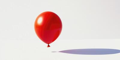 Large vibrant red balloon floating against minimalistic white background photo