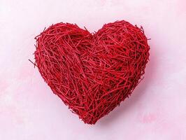 Simple red heart shape on light pink background for Valentines day design and decor photo