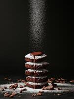 Decadent stack of brownies dusted with powdered sugar and cocoa on dark background photo