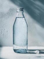Refreshing frosted glass bottle of water on textured surface photo