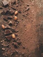 Indulgent broken chocolate bar with nuts on cocoa dusted surface photo