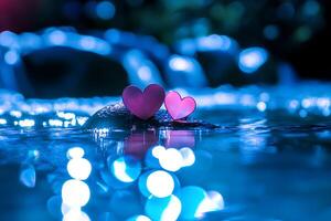 A romantic scene of two hearts resting on a stone in the water, with a blue bokeh background. Perfect for themes of love, romance, and nature. photo