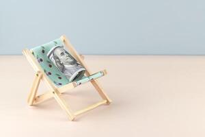 Chaise lounge with dollars on a light background. photo