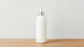 Minimalistic White Cosmetic Bottle with Metal Nozzle on Wood photo