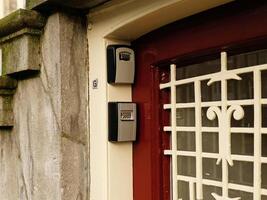 Smart key lock mounted on a wall or door frame for renting apartment. Safe Key Box is used when the guest arrives at the touristic flat and the host can't open the door. Safe access to living space. photo