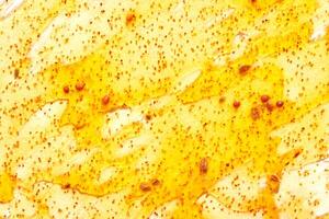 Close up of honeycomb with golden honey drizzle and pollen granules creating natural texture. photo