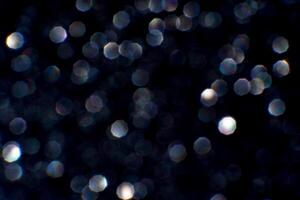 Sparkling bokeh lights on a dark background with hexagonal shapes and soft glow effects. photo