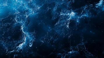 Abstract dark blue water texture with white foam, resembling ocean waves. photo