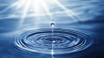Water droplet falling, creating concentric ripples on a calm surface, backlit by sunlight. photo