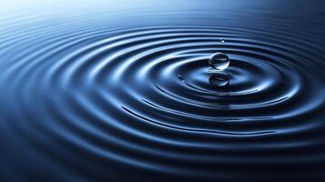 Water droplet impacting calm water, creating concentric ripples. photo