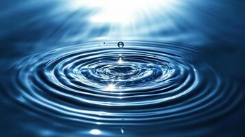 Water droplet impacting still surface, creating concentric ripples and light reflections. photo