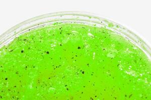 Vibrant green slime texture with black specks in close up for creative projects. photo