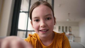 Webcam display point of view POV screen modern happy Caucasian little child girl daughter scrolling screen mobile phone smartphone tech kid rejoice touchscreen at home smiling schoolgirl typing gadget video