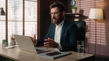 Working online Caucasian middle-aged business man businessman guy male employer in office typing laptop computer failure angry shouting argument mad furious scold pointing at camera screaming rage video