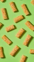 Golden Crispy Snack Bars on a Vibrant Green Background photo