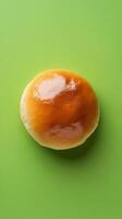 A Golden Round Bun on a Green Background photo