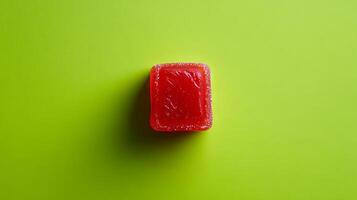 Vibrant Red Jelly Candy on Lime Green Background photo