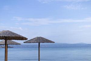 straw umbrellas on the background of the horizon line on the sea coast photo