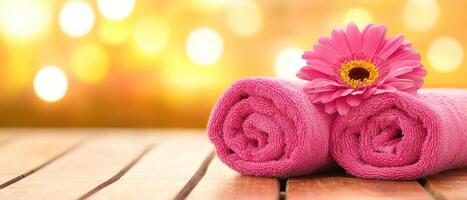Soft pink towels are elegantly arranged with vibrant flower, creating serene and inviting atmosphere. Perfect for spa or relaxation setting photo