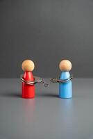 Bound by contract. People tied with handcuffs. Promise. Bound by agreements and promises. The power of one over the other. Slavery and obedience. Freed from shackles. Break off relationships photo