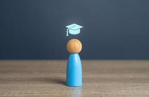 A man with a graduate cap symbol, the concept of getting an education and graduating from training. Reach graduation. Development paths and subsequent stages. Choose a new direction for learning. photo