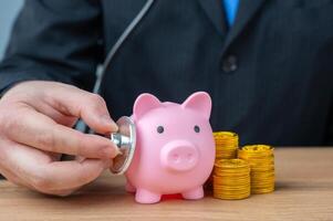 The businessman listens to the pig piglet with a stethoscope. Financial health. Liquidity of assets. Economic security. Accounting management. photo