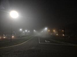 Night empty highway in mist and lamp posts lights photo
