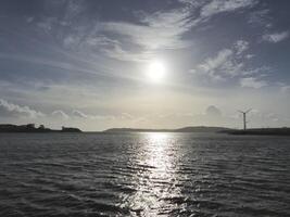 Spike Island in Ireland as it is seen from another island, with ocean waters and cloudy sky photo