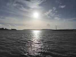 Spike Island in Ireland as it is seen from another island, with ocean waters and cloudy sky photo