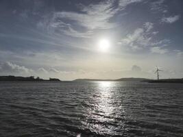Spike Island in Ireland as it is seen from another island, with ocean waters and cloudy sky photo