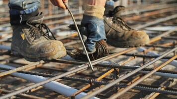 Worker tying steel reinforcement bars at construction site video