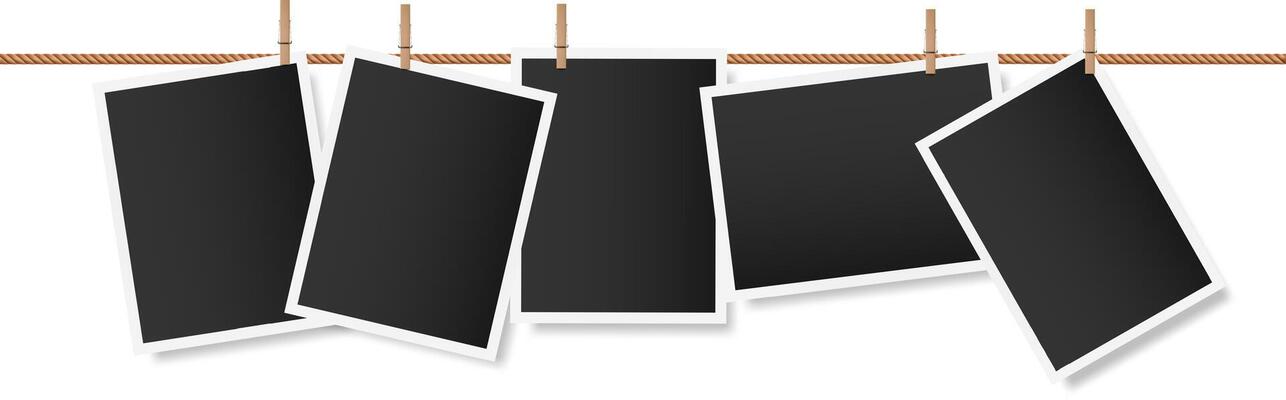Five blank instant photographs are hanging on a clothesline held by wooden clothespins, creating a nostalgic display of memories yet to be made