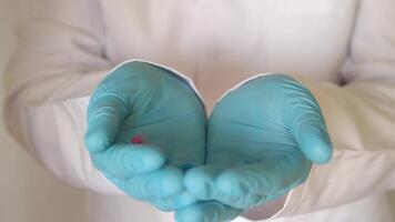Close-up pills fall into the gloved hands. Close-up video