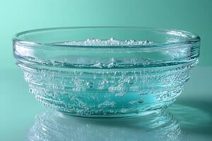 Effervescent Bubbles in Glass Bowl on Teal Background for Freshness Concept photo