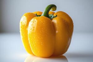 macro view highlights single glossy yellow bell pepper standing upright displaying its smooth surface and vibrant hue. Soft lighting enhances its fresh appearance photo