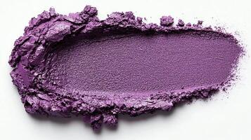 Deep purple eyeshadow is artistically smudged across clean white surface revealing rich pigment and detailed brush strokes highlight its unique texture and tonal qualities photo
