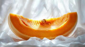 vibrant orange pumpkin slice showcases its smooth inner surface and seeds set against bright white background emphasizes its rich color and natural details photo